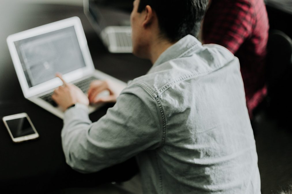 propertystrem employee pointing to a social media publishing tool on a laptop