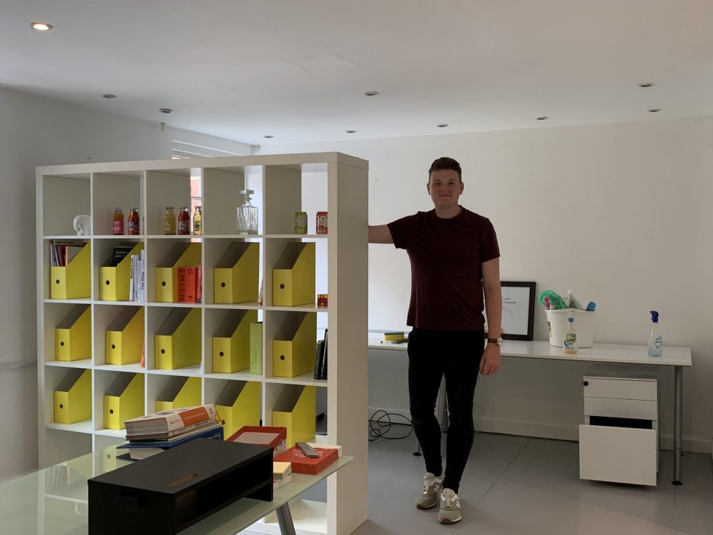 22 group employee standing next to a book case 