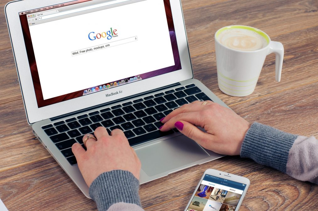 lady typing into google on a laptop