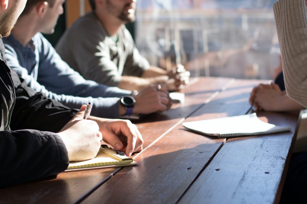 property stream employees sitting round a table planning and taking notes