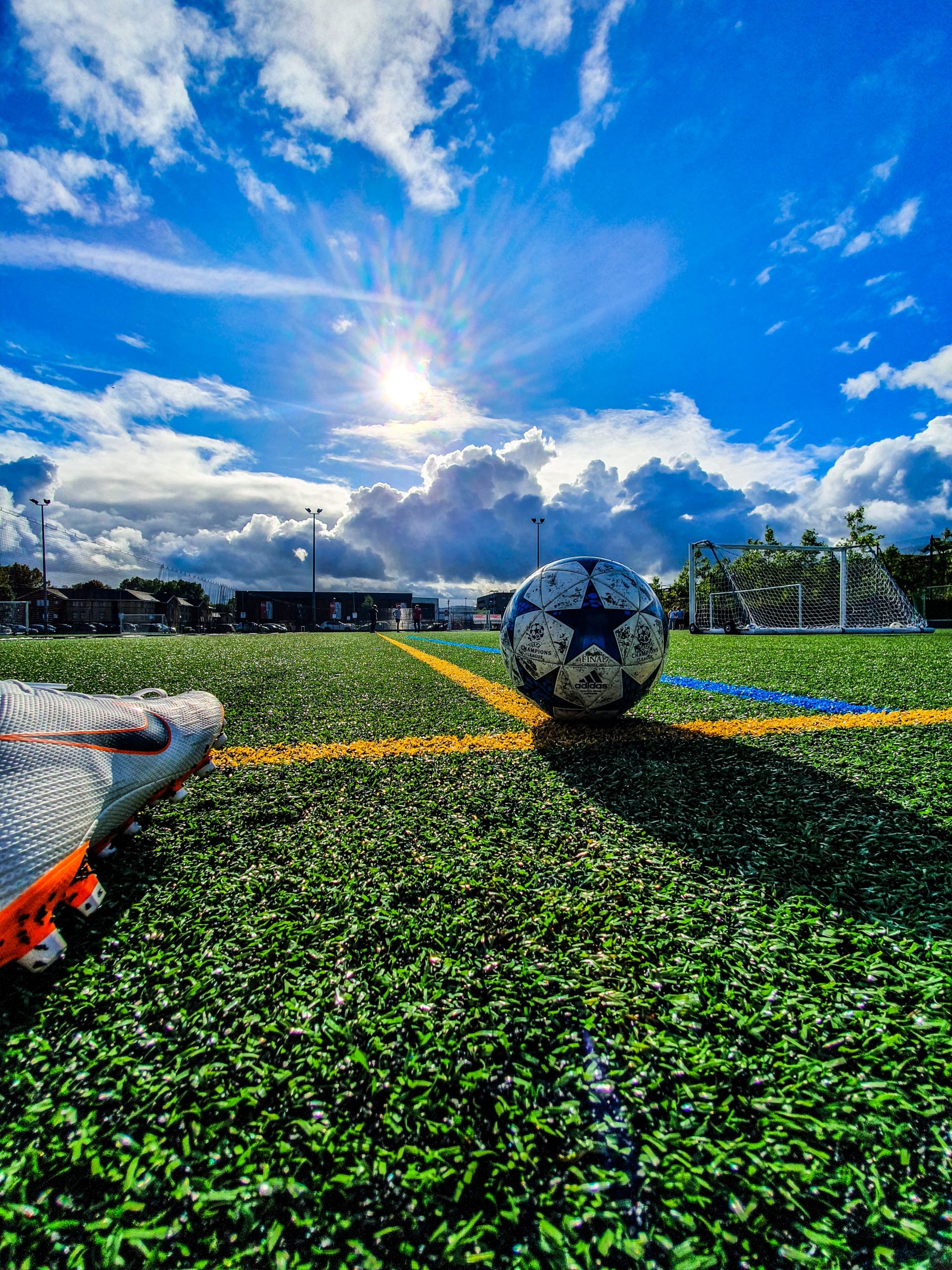 Football on a green football pitch bathing in summer sunshine