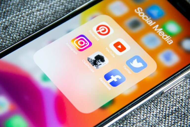 Mobile phone screen showing social media icons. Social media should be part of an estate agent's content strategy.
